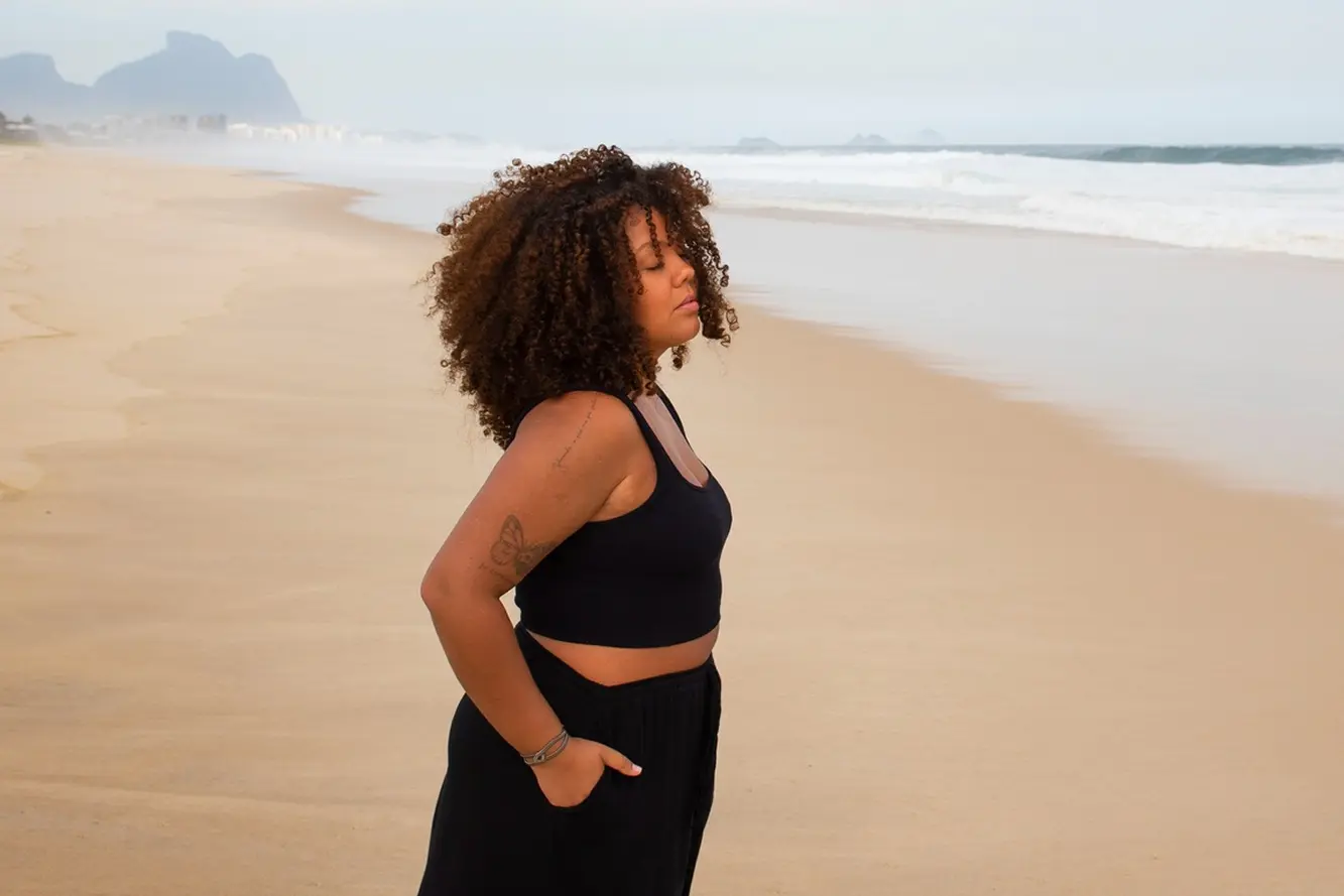a woman stands on the beach